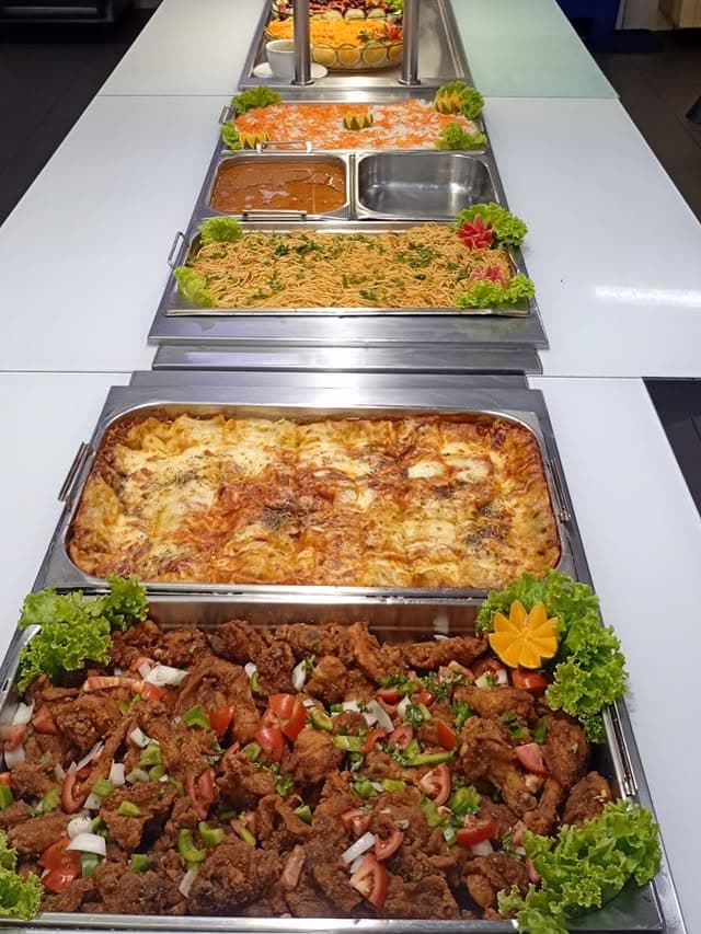 Lasanha, frango e acompanhamentos em buffet industrial